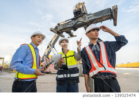 Asian Logistics Manager Pointing at Reach Stacker Crane for Thailand Port Operations Training 139325474
