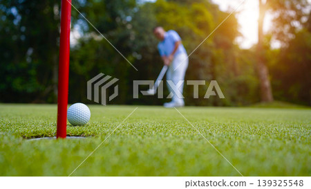 Golfers are putting golf in the evening golf course golf backglound. Golfers are putting golf in the evening golf course golf backglound. 139325548