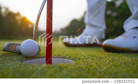 Golfers are putting golf in the evening golf course golf backglound. Golfers are putting golf in the evening golf course golf backglound. 139325551