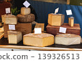 Variety of Artisan Cheeses on Wooden Display at Food Market 139326513