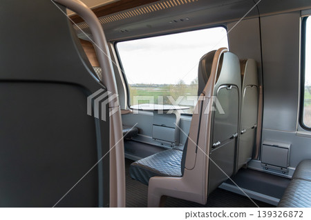 Modern train first class interior with leather seats, window view and clean design in Belgium. Business travel, premium transport service, passenger comfort, mobility concept, corporate travel Modern train first class interior with leather seats, window view and clean design in Belgium. Business travel, premium transport service, passenger comfort, mobility concept, corporate travel 139326872