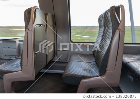 Modern train first class interior with leather seats, window view and clean design in Belgium. Business travel, premium transport service, passenger comfort, mobility concept, corporate travel Modern train first class interior with leather seats, window view and clean design in Belgium. Business travel, premium transport service, passenger comfort, mobility concept, corporate travel 139326873