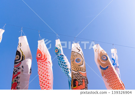 五彩繽紛的鯉魚彩帶在藍天下成排懸掛。 139326904