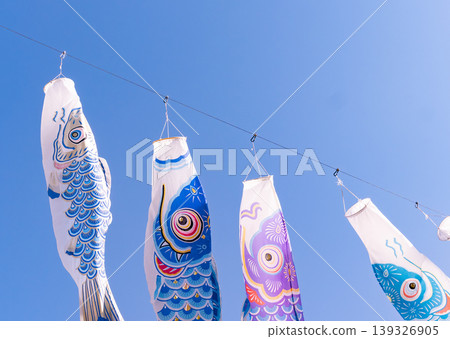 一排排色彩鮮豔的鯉魚彩帶懸掛在藍天下。 139326905