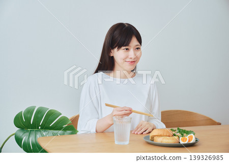 A woman eating breakfast; a natural, everyday meal scene. 139326985
