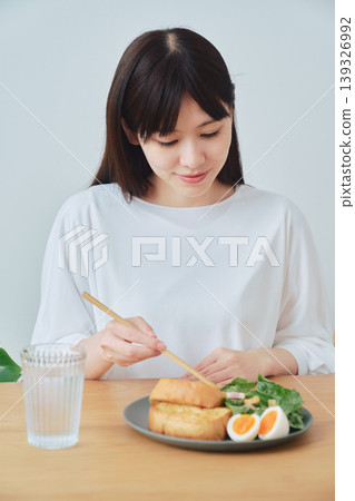 A woman eating breakfast; a natural, everyday meal scene. 139326992