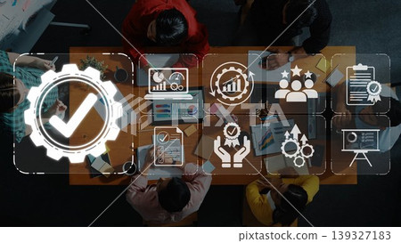 Aerial view of a diverse team discussing strategies around a table with laptops and documents. Business icons highlight themes of collaboration, growth, and success in the workspace. Sigmoid Aerial view of a diverse team discussing strategies around a table with laptops and documents. Business icons highlight themes of collaboration, growth, and success in the workspace. Sigmoid 139327183