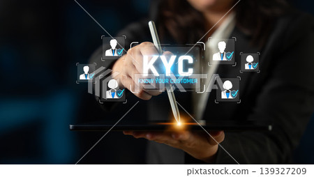 A business professional demonstrates the KYC concept on a digital tablet, highlighting user profiles and customer identification in a modern, technological setting. Sigmoid A business professional demonstrates the KYC concept on a digital tablet, highlighting user profiles and customer identification in a modern, technological setting. Sigmoid 139327209