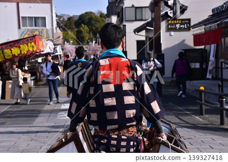 A man participating in the Inuyama Spring Festival in Inuyama City, Aichi Prefecture, walks through the castle town wearing a traditional happi coat and a brightly colored obi belt. A man participating in the Inuyama Spring Festival in Inuyama City, Aichi Prefecture, walks through the castle town wearing a traditional happi coat and a brightly colored obi belt. 139327418