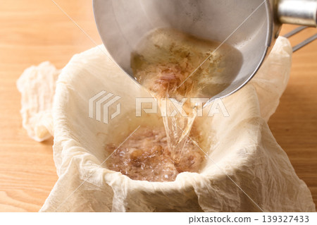 Strain the bonito broth through cheesecloth. Strain the bonito broth through cheesecloth. 139327433