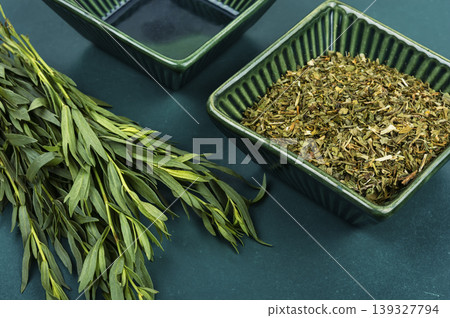 Green tarragon herb with dried leaves in bowl Green tarragon herb with dried leaves in bowl 139327794