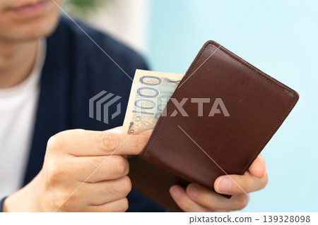 一個手頭拮据的男人，錢包正拿在手上。 139328098