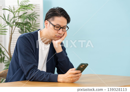 A man who is worried about seeing a smartphone A man who is worried about seeing a smartphone 139328113