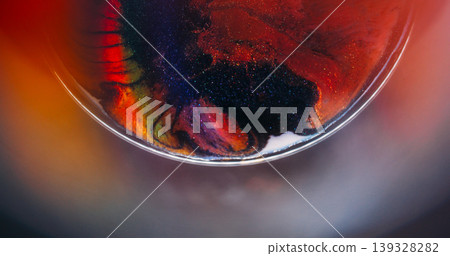 Colorful ink rainbow. Sparkling fluid. Defocused orange blue purple glitter particles spreading on abstract vibrant creative background. Colorful ink rainbow. Sparkling fluid. Defocused orange blue purple glitter particles spreading on abstract vibrant creative background. 139328282