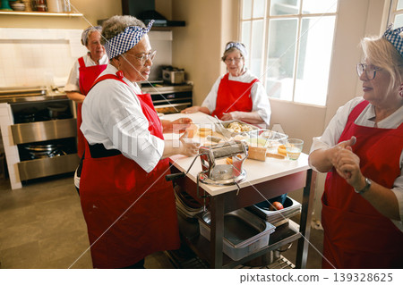 Senior women engaged in a lively discussion while baking in a workspace Senior women engaged in a lively discussion while baking in a workspace 139328625