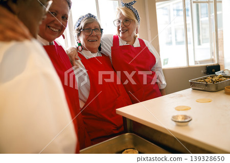 senior women sharing a playful moment while baking in a bright kitchen senior women sharing a playful moment while baking in a bright kitchen 139328650