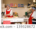 Two senior women smiling and talking while cooking together in a kitchen 139328672