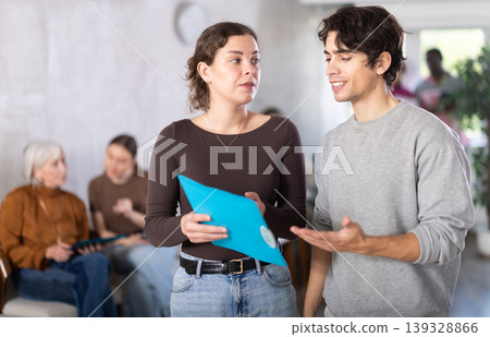 Young female secretary talking with young guy in reception area Young female secretary talking with young guy in reception area 139328866