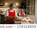 Senior Caucasian Woman Making Fresh Pasta with Machine in Professional Kitchen 139328899