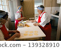 Senior Caucasian and Black women chefs preparing dough in a commercial kitchen setting 139328910
