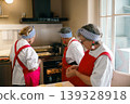 Senior Caucasian women in red aprons baking pastries in a professional kitchen setting 139328918