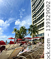 Beach chairs alongside scenes of a Hawaiian beach resort. 139329002