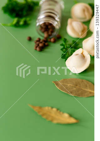 Cooking ingredients with tortellini and spices on green background Cooking ingredients with tortellini and spices on green background 139329447