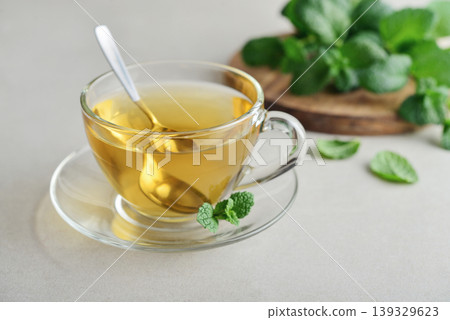Glass cup of fresh mint tea on a light background with mint leaves 139329623