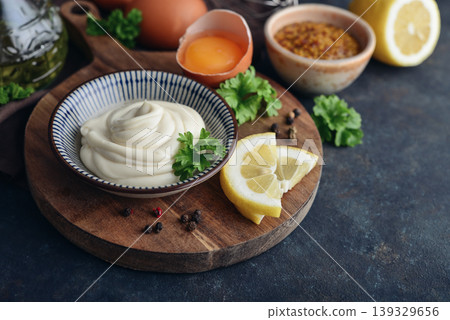 Homemade mayonnaise in a bowl on a wooden board with fresh ingredients Homemade mayonnaise in a bowl on a wooden board with fresh ingredients 139329656