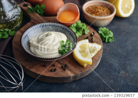 Homemade mayonnaise in a bowl on a wooden board with fresh ingredients Homemade mayonnaise in a bowl on a wooden board with fresh ingredients 139329657