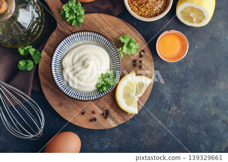 Top view of homemade mayonnaise in a bowl on a wooden board with fresh ingredients Top view of homemade mayonnaise in a bowl on a wooden board with fresh ingredients 139329661