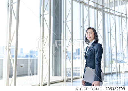 A businesswoman in her 40s standing in the lobby. 139329709
