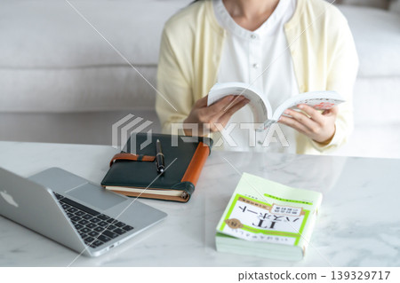 A young woman studying for an IT certification at home; career advancement; risking; home learning; generating AI; faceless. 139329717