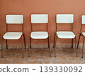 Empty chairs lining wall symbolizing waiting and anticipation 139330092
