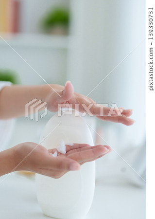 Asian women hands pressing automatic soap dispenser washing hand hygiene morning routine skincare bathroom sink home white bottle touchless pump sanitizer 139330731