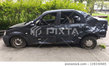 Side view of a damaged car with visible dents and impact marks, symbolizing the consequences of an accident, vehicle damage and the concept of road safety. Side view of a damaged car with visible dents and impact marks, symbolizing the consequences of an accident, vehicle damage and the concept of road safety. 139330985