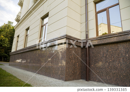 Close up view of part of a building facade with the surface of granite wall. Natural stone materials. Close up view of part of a building facade with the surface of granite wall. Natural stone materials. 139331385