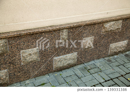 Close up view of part of a building facade with the surface of granite wall. Natural stone materials. Close up view of part of a building facade with the surface of granite wall. Natural stone materials. 139331386