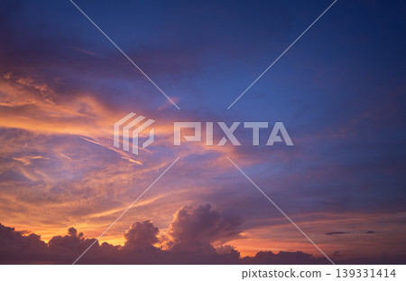 Bright sunset with setting sun behind vivid orange and yellow clouds 139331414