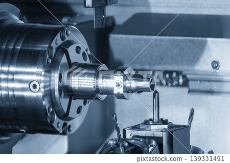 Advanced multi-tasking CNC machine producing high precision metal shaft parts in a blue-toned industrial scene. Advanced multi-tasking CNC machine producing high precision metal shaft parts in a blue-toned industrial scene. 139331491