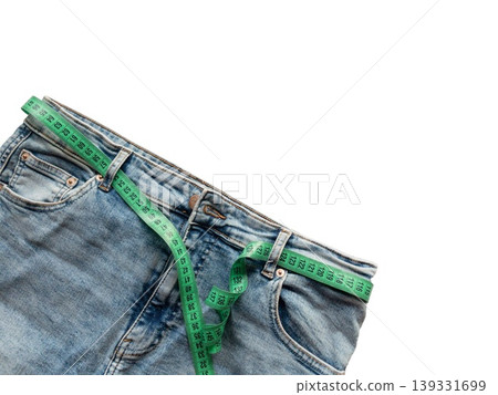 Blue jeans with measuring tape isolated on transparent background. Weight loss, obesity control, waist measurement, slimming, dietetics and healthy lifestyle concept. Blue jeans with measuring tape isolated on transparent background. Weight loss, obesity control, waist measurement, slimming, dietetics and healthy lifestyle concept. 139331699