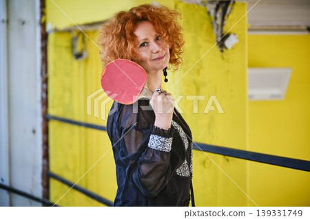 Red haired woman with ping pong paddle lifestyle portrait Red haired woman with ping pong paddle lifestyle portrait 139331749