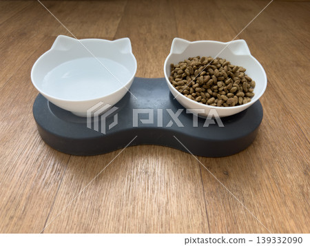 White cat shaped food and water bowls on wooden floor, dry food and fresh water feeding station for indoor cat White cat shaped food and water bowls on wooden floor, dry food and fresh water feeding station for indoor cat 139332090
