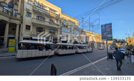 View of a tourist train running through the main street of Gozo island 139333135