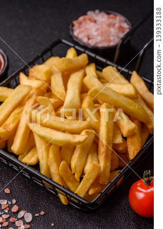 Crispy, fresh, golden French fries with salt, unhealthy takeaway food. French fries Crispy, fresh, golden French fries with salt, unhealthy takeaway food. French fries 139333188