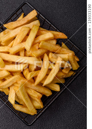 Crispy, fresh, golden French fries with salt, unhealthy takeaway food. French fries 139333190