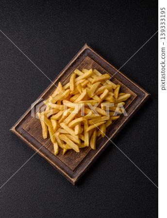 Crispy, fresh, golden French fries with salt, unhealthy takeaway food. French fries Crispy, fresh, golden French fries with salt, unhealthy takeaway food. French fries 139333195
