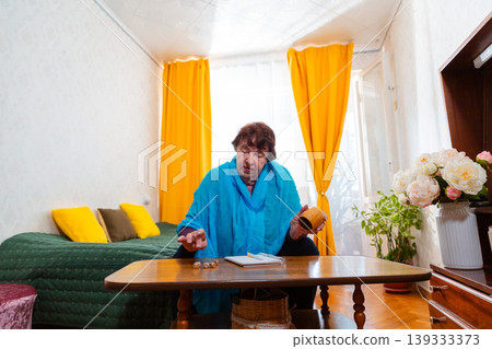 Elderly woman enjoying a dice game as part of daily routine at home. Focus and calm mood. Concept of relaxation and happiness. Wide shot 139333373