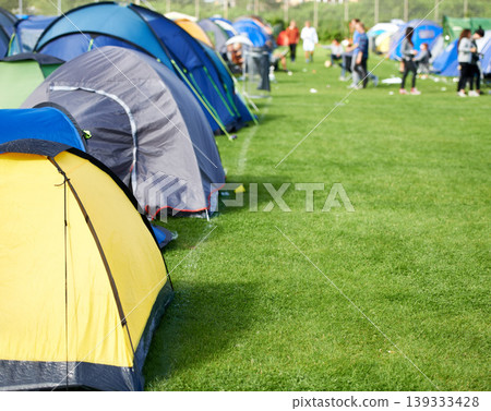 Music festival, camping and tents in park with people in summer, holiday or field at concert in countryside. Camp, site or adventure shelter on grass in woods or group at carnival in morning of rave Music festival, camping and tents in park with people in summer, holiday or field at concert in countryside. Camp, site or adventure shelter on grass in woods or group at carnival in morning of rave 139333428