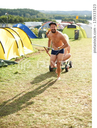 Music festival, alcohol and man with wagon outdoors for social party, celebration and camp event. Crazy, friends and person with beer or beverage at musical concert for freedom, vacation and games Music festival, alcohol and man with wagon outdoors for social party, celebration and camp event. Crazy, friends and person with beer or beverage at musical concert for freedom, vacation and games 139333523